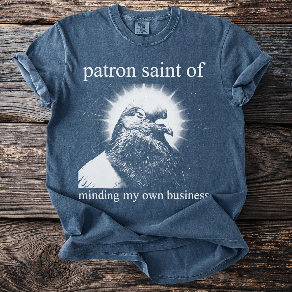 T-shirt with a pigeon graphic and text "patron saint of minding my own business."