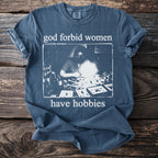 Blue Comfort Colors t-shirt with "god forbid women have hobbies" text and vintage graphic.