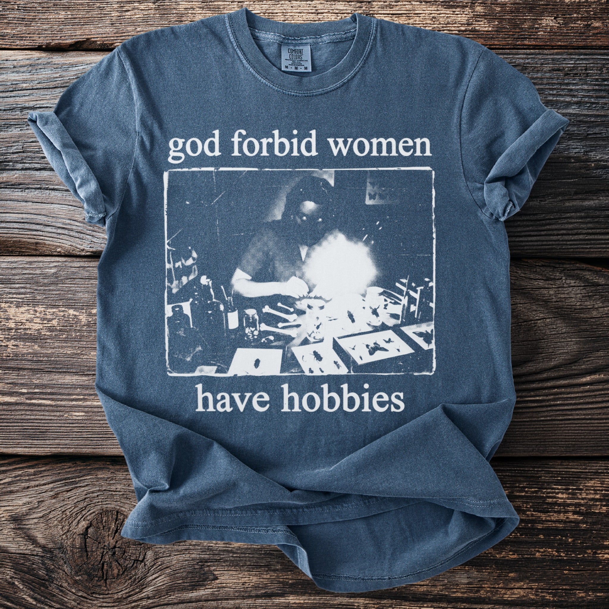 Blue Comfort Colors t-shirt with "god forbid women have hobbies" text and vintage graphic.