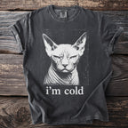 Dark t-shirt with a white graphic of a stern Sphynx cat and the text "i'm cold".