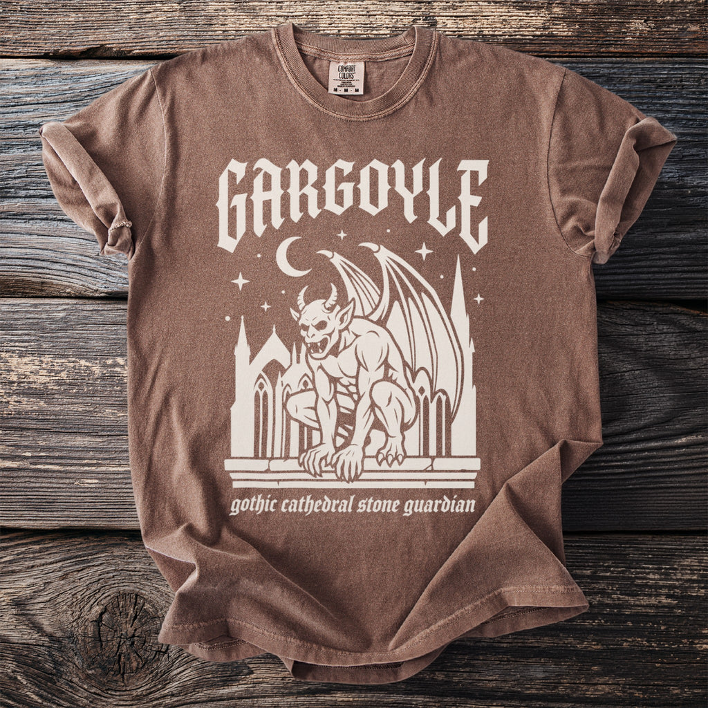 Brown t-shirt with cream gothic graphic featuring a winged gargoyle and text.