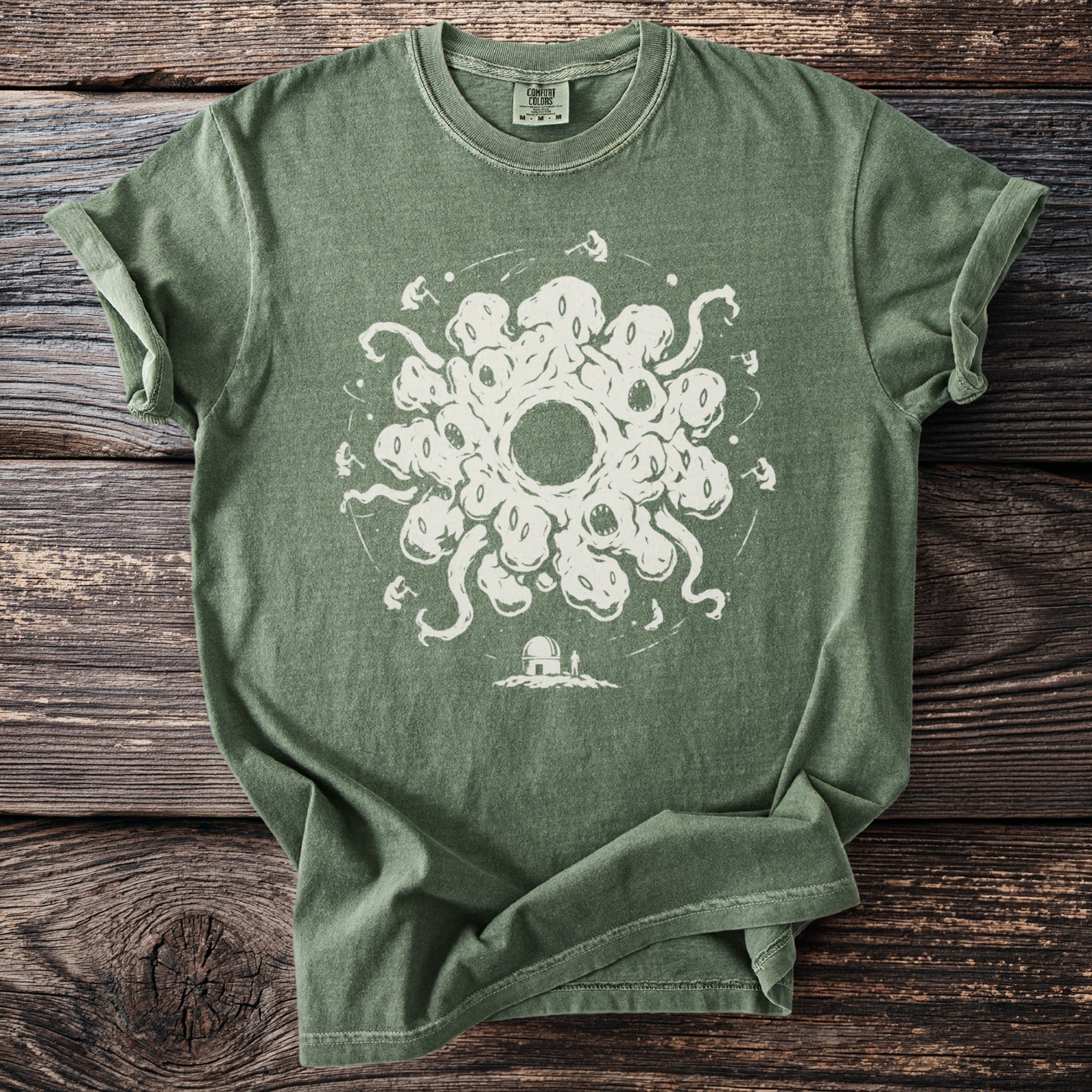 Green t-shirt with a circular alien creature graphic and an observatory at the bottom.