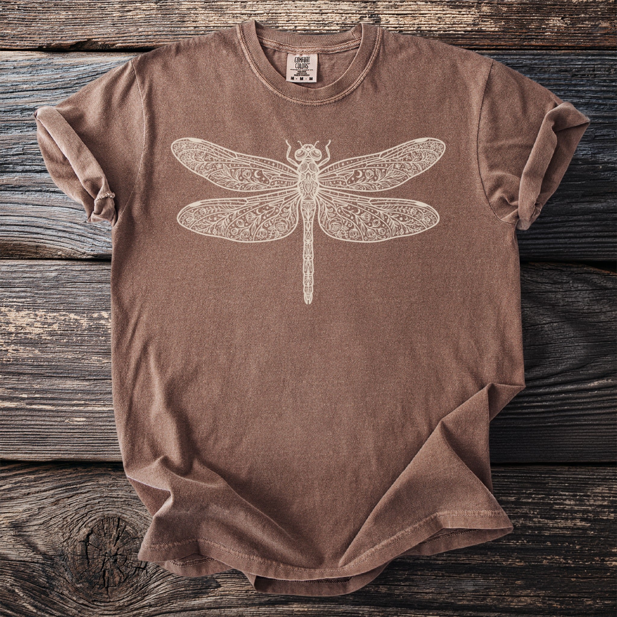 Brown t-shirt with a cream-colored, ornate dragonfly graphic on the front.