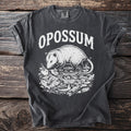 Dark gray t-shirt with white opossum graphic and text "OPOSSUM"