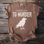 Brown t-shirt with white text "I PLEAD NOT GUILTY TO MURDER" and crow silhouette.