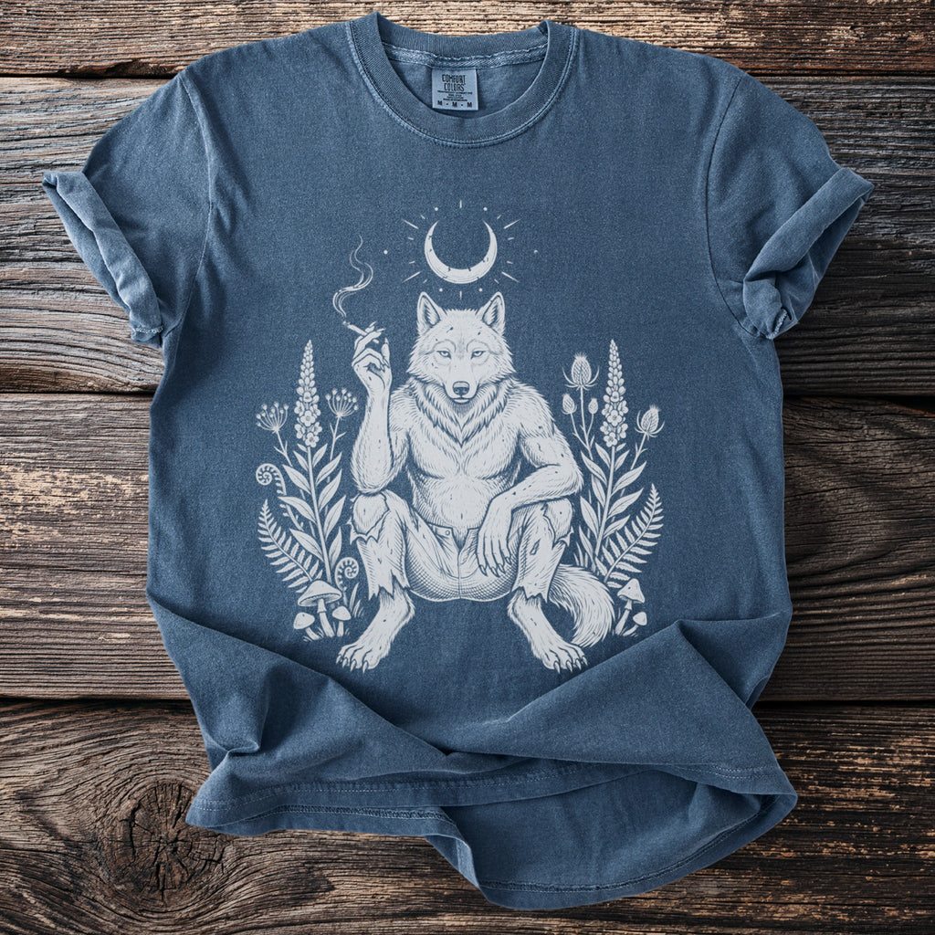 Blue t-shirt with white illustration of a wolfman smoking, surrounded by plants and a crescent moon.