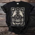 Black t-shirt with cream graphic featuring hands, crystal ball, moths, candles, and celestial symbols.