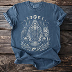 Blue t-shirt with shaman, wolf, raven, bones, and moon phases graphic.
