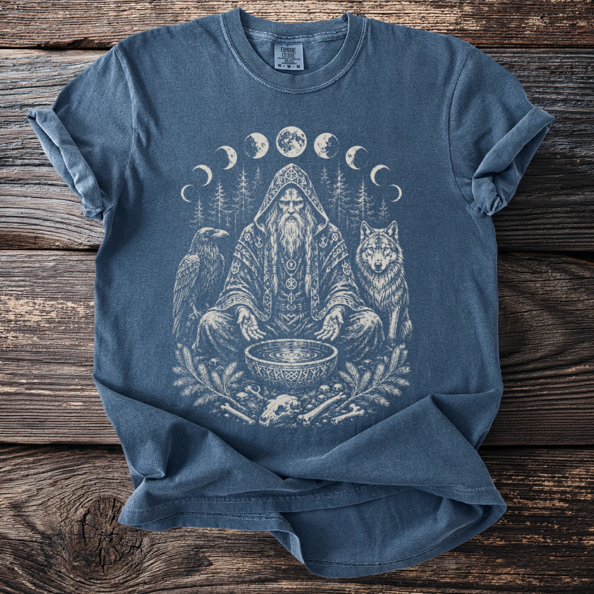 Blue t-shirt with shaman, wolf, raven, bones, and moon phases graphic.
