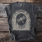 Dark gray t-shirt with a cream linework illustration of a dragonfly in a floral and mushroom arch.