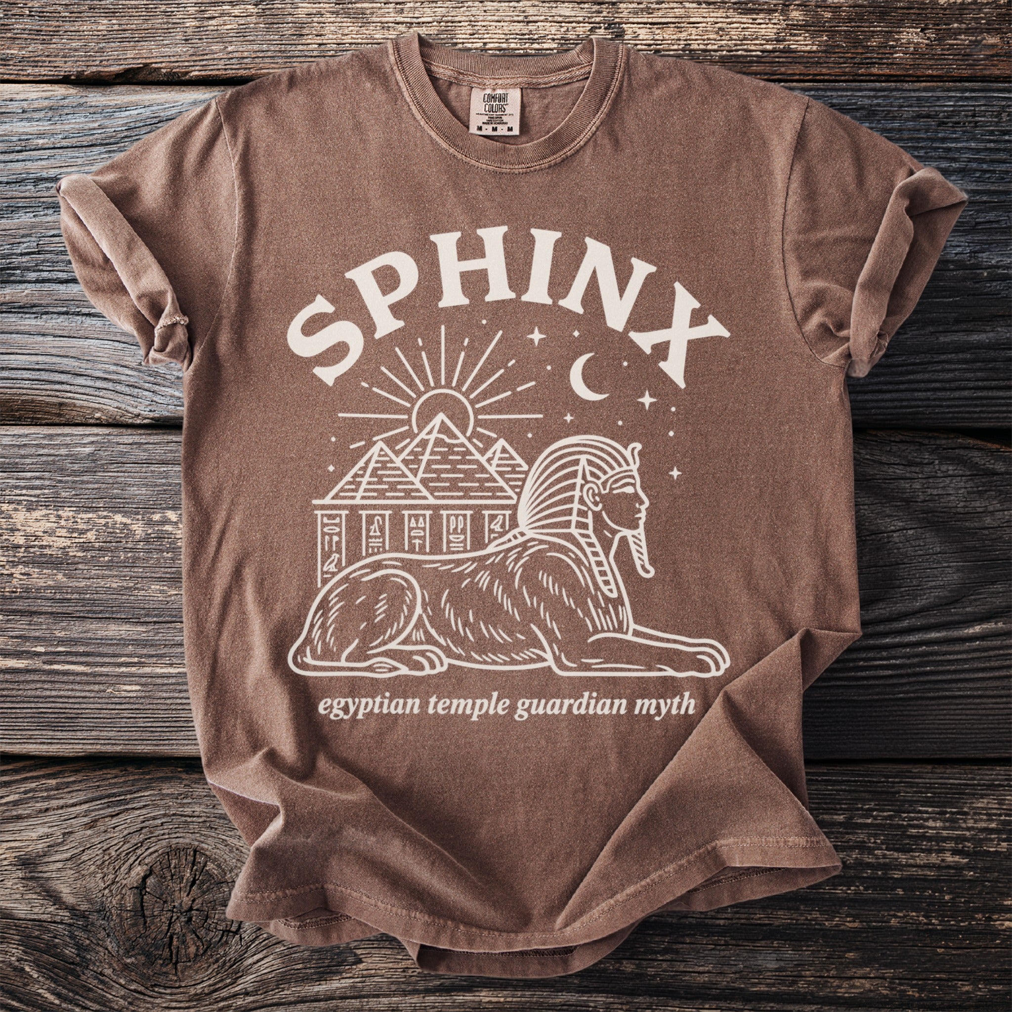 Brown t-shirt with Sphinx and pyramids graphic, reading "Sphinx" and "egyptian temple guardian myth."