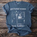Blue t-shirt with white graphic of three witches and text "god forbid women have hobbies".