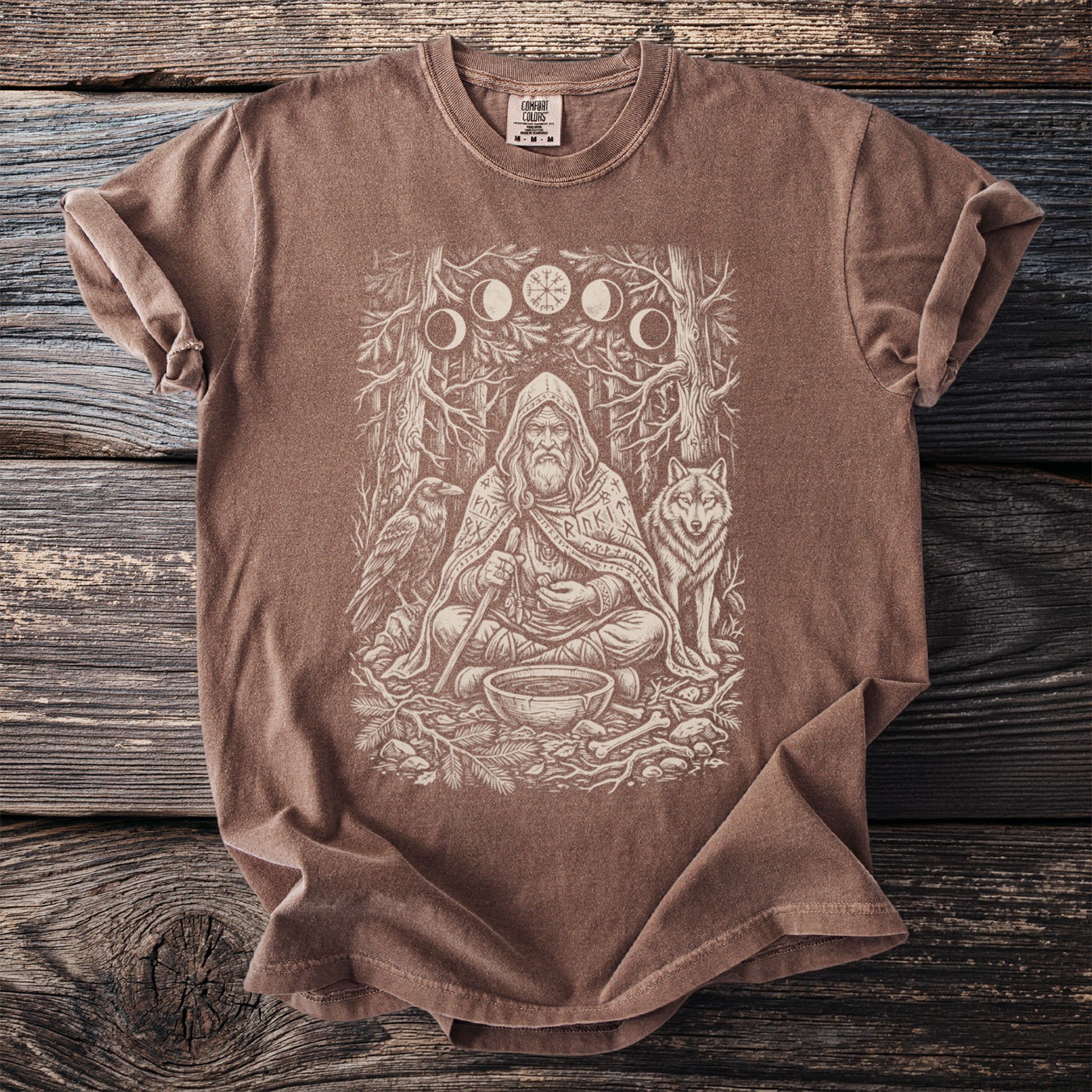 Brown t-shirt with a distressed print of a shaman, wolf, raven, and moon phases.