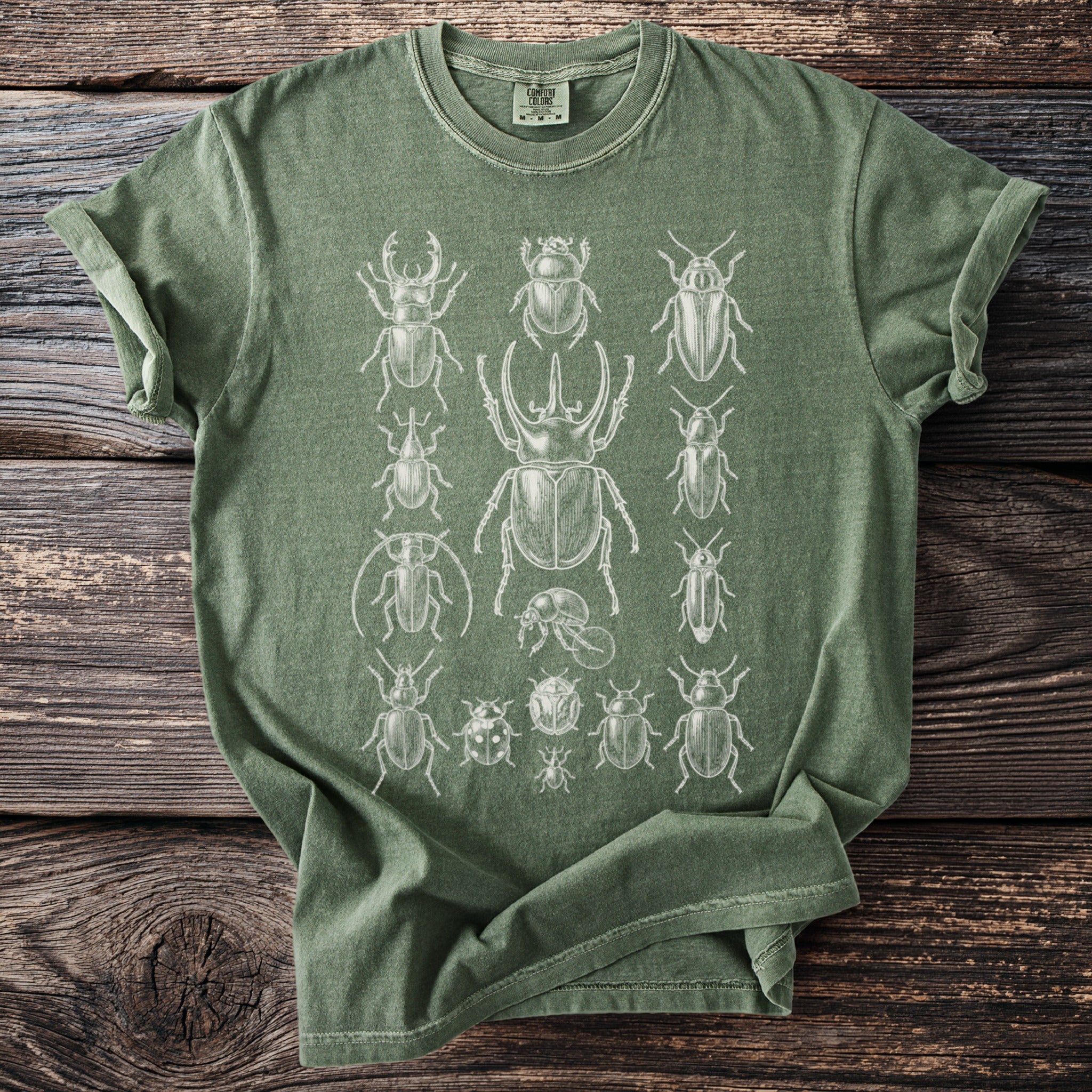 Green t-shirt with a white illustration of various beetles and insects.