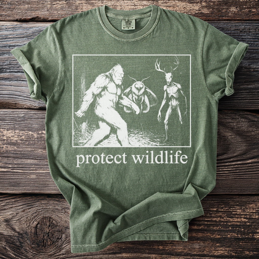 Green t-shirt with Bigfoot, moth, and skeleton deer graphic and "protect wildlife" text.