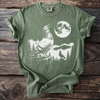 Green t-shirt with white graphic of two pigeons under a full moon.
