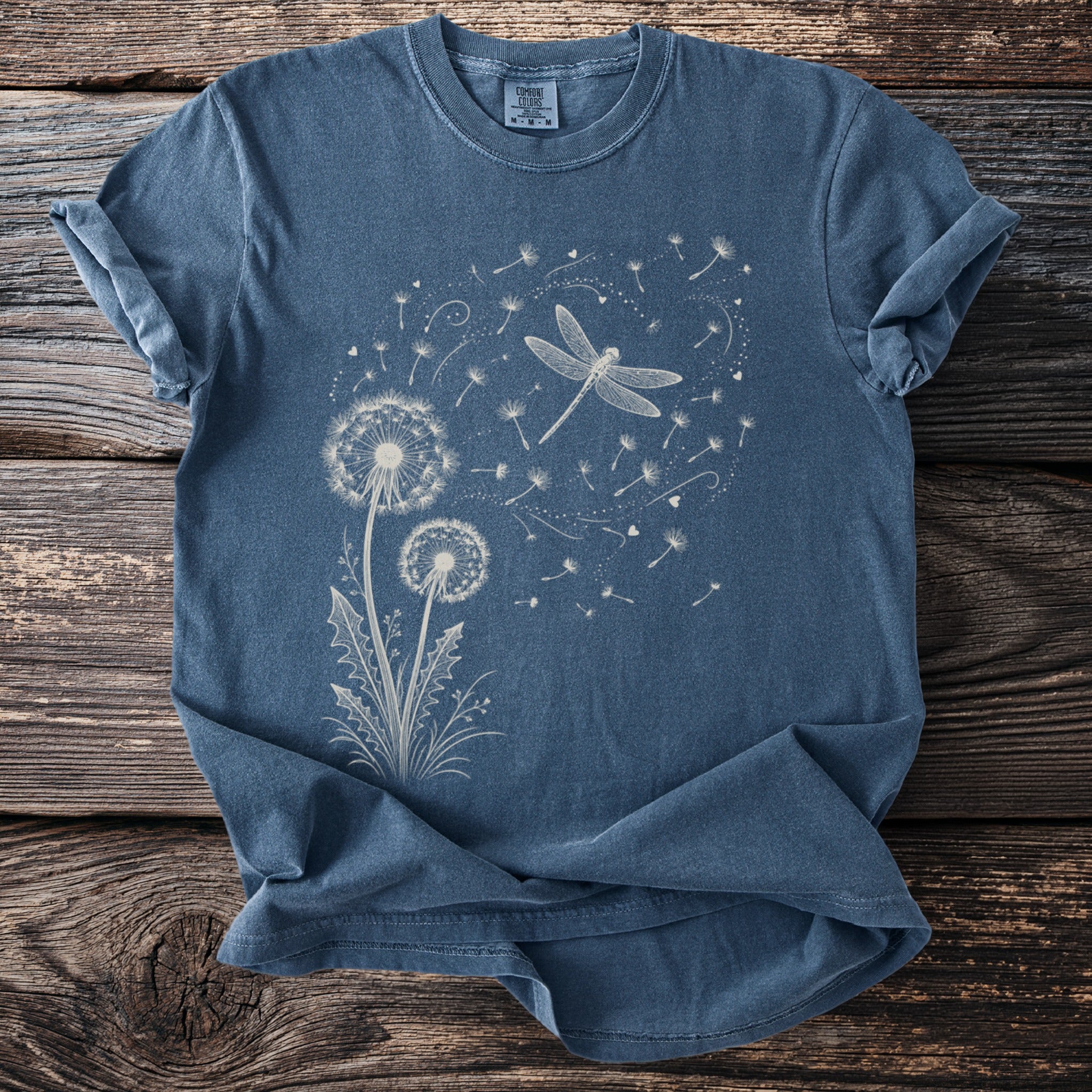 Blue t-shirt with white dandelion and dragonfly graphic.