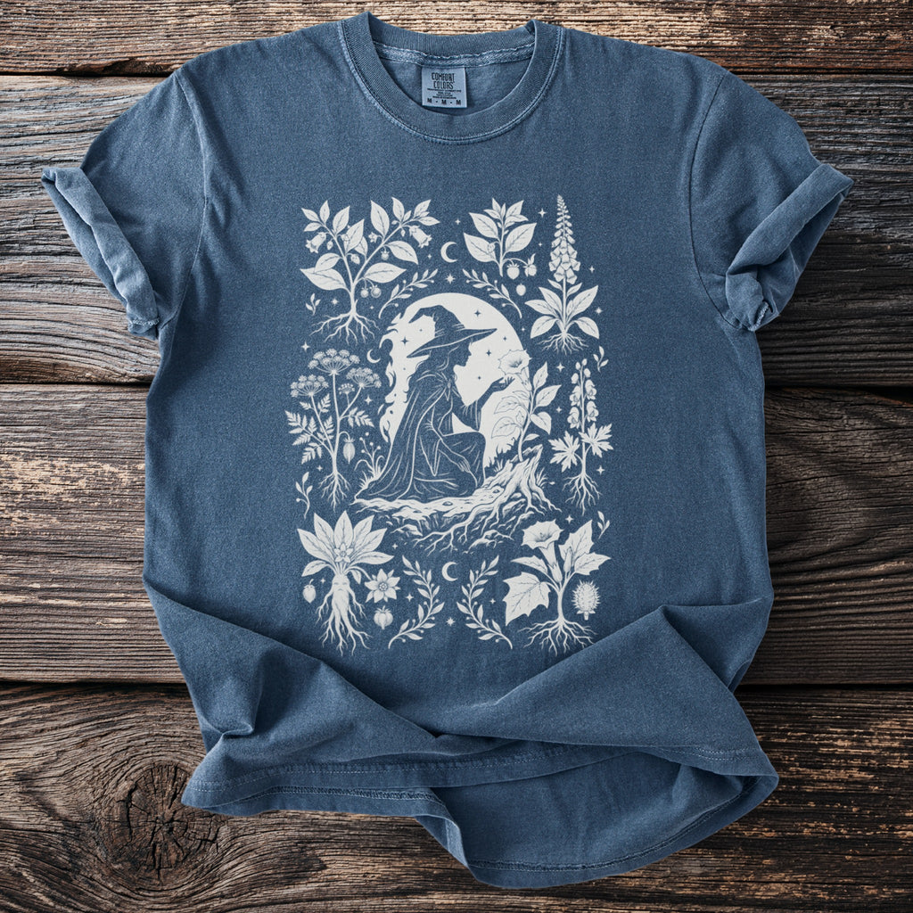 Blue t-shirt with white witch, plants and moon design.