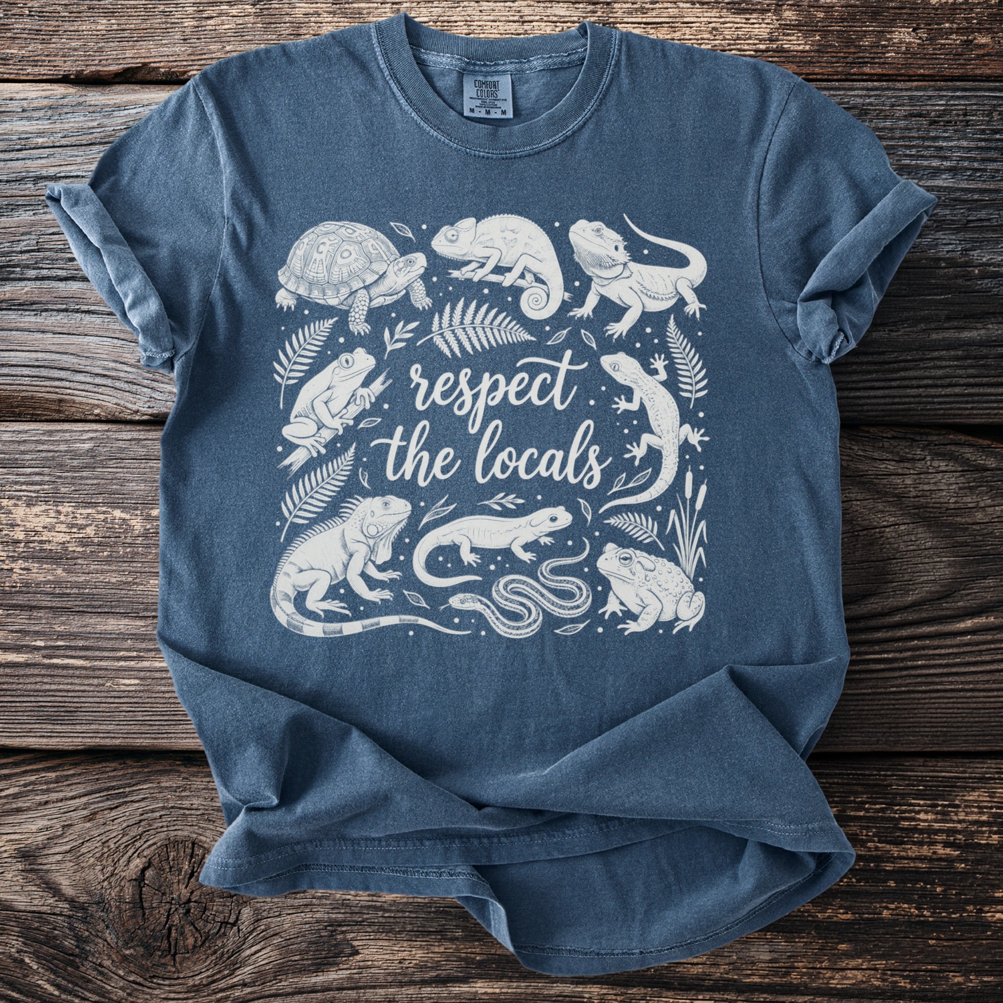 Blue t-shirt with a white line drawing of reptiles and amphibians with "respect the locals" text.