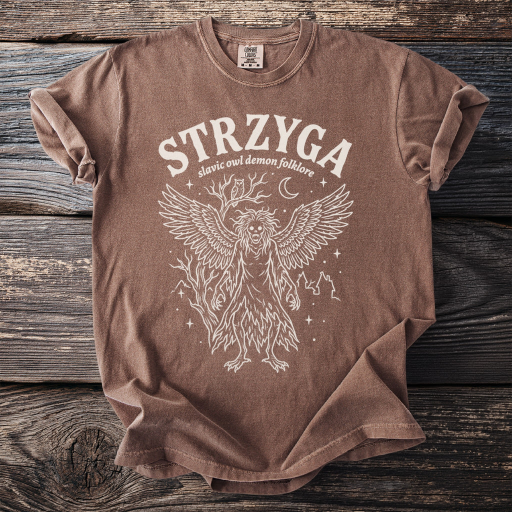 Brown t-shirt with white Strzyga Slavic owl demon folklore graphic design.