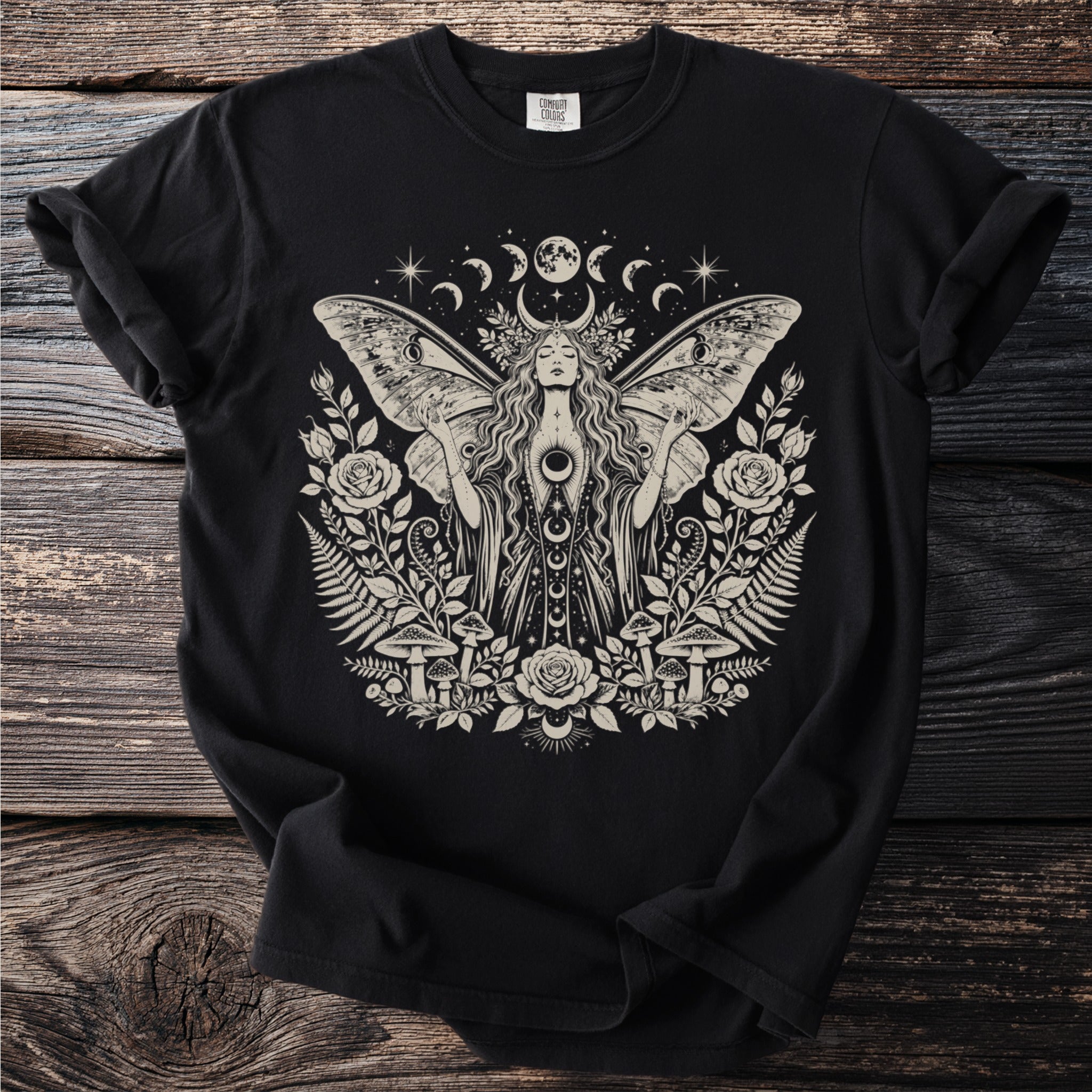 Black t-shirt with a cream moth woman surrounded by flowers, mushrooms, and moons.