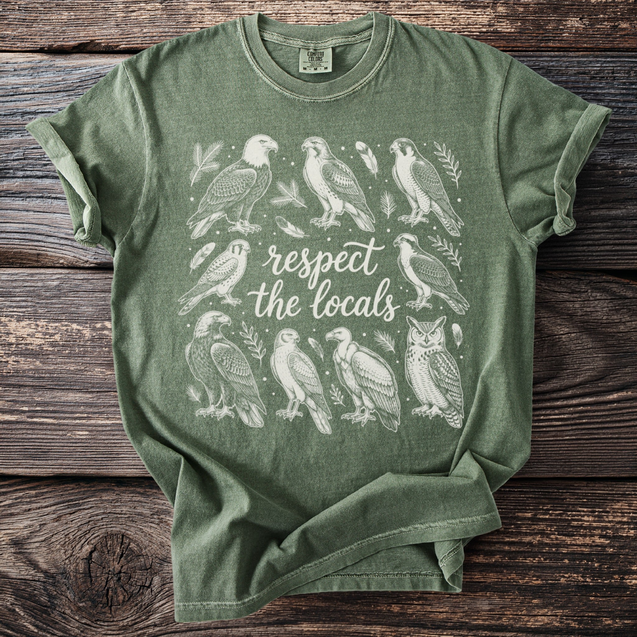 Green t-shirt with white line art of various birds and text "respect the locals".
