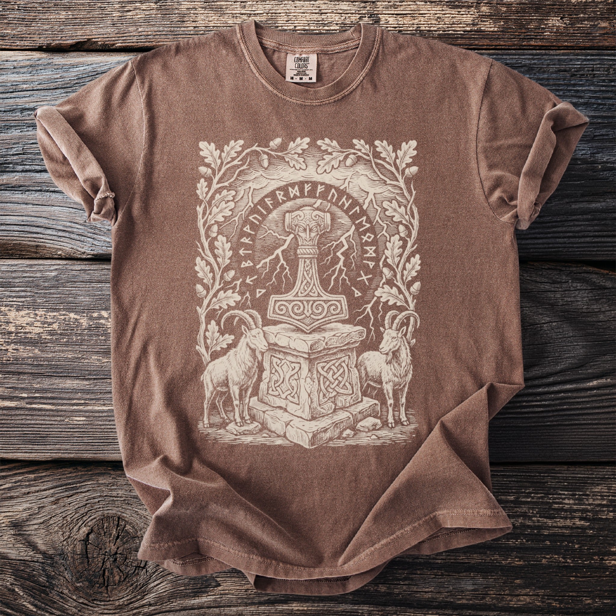 Brown t-shirt with Thor's hammer, runic circle, and goats, framed by oak branches.