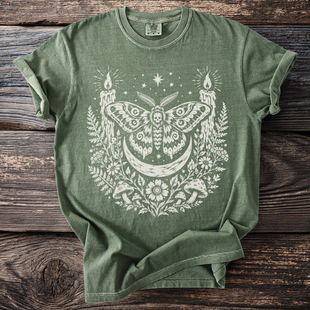 Green t-shirt with white occult moth, moon, candles, mushrooms, and floral design.