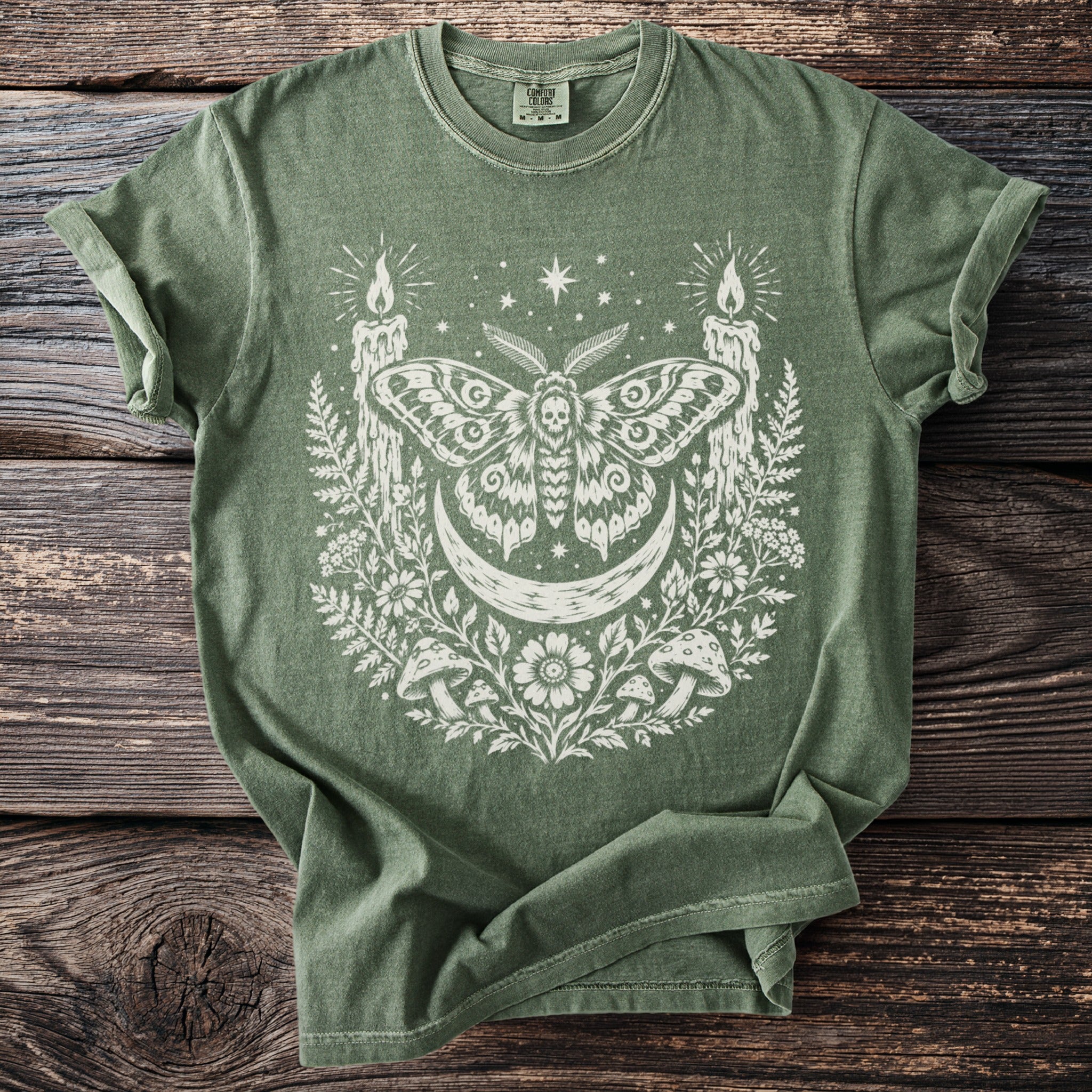 Green t-shirt with white occult moth, moon, candles, mushrooms, and floral design.