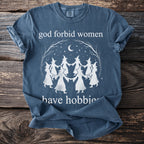 Blue t-shirt with "god forbid women have hobbies" and witch circle graphic.