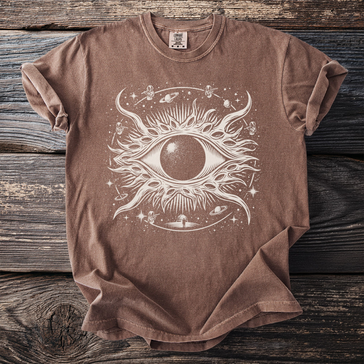 Brown t-shirt with a white celestial eye and space-themed graphic design.