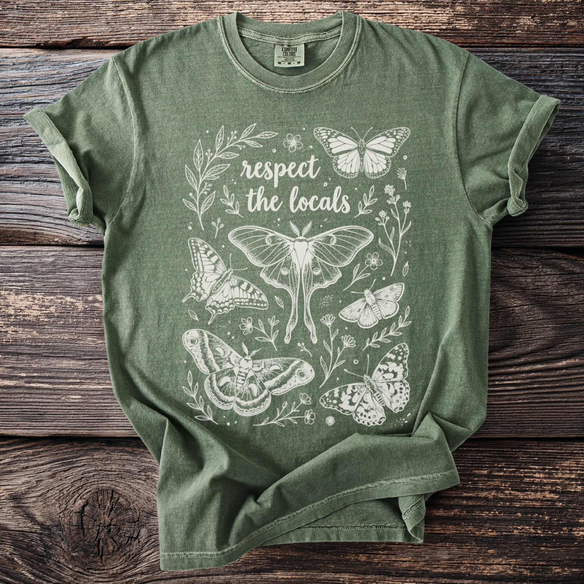 Green t-shirt with white line art of various butterflies and "respect the locals" text.