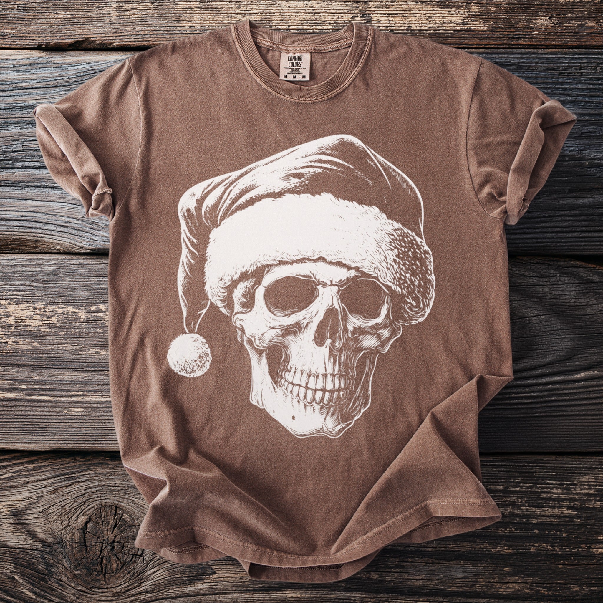 Brown t-shirt with a white graphic of a skull wearing a Santa hat.