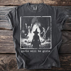 Dark grey t-shirt with image of witches around a campfire and text "girls will be girls".