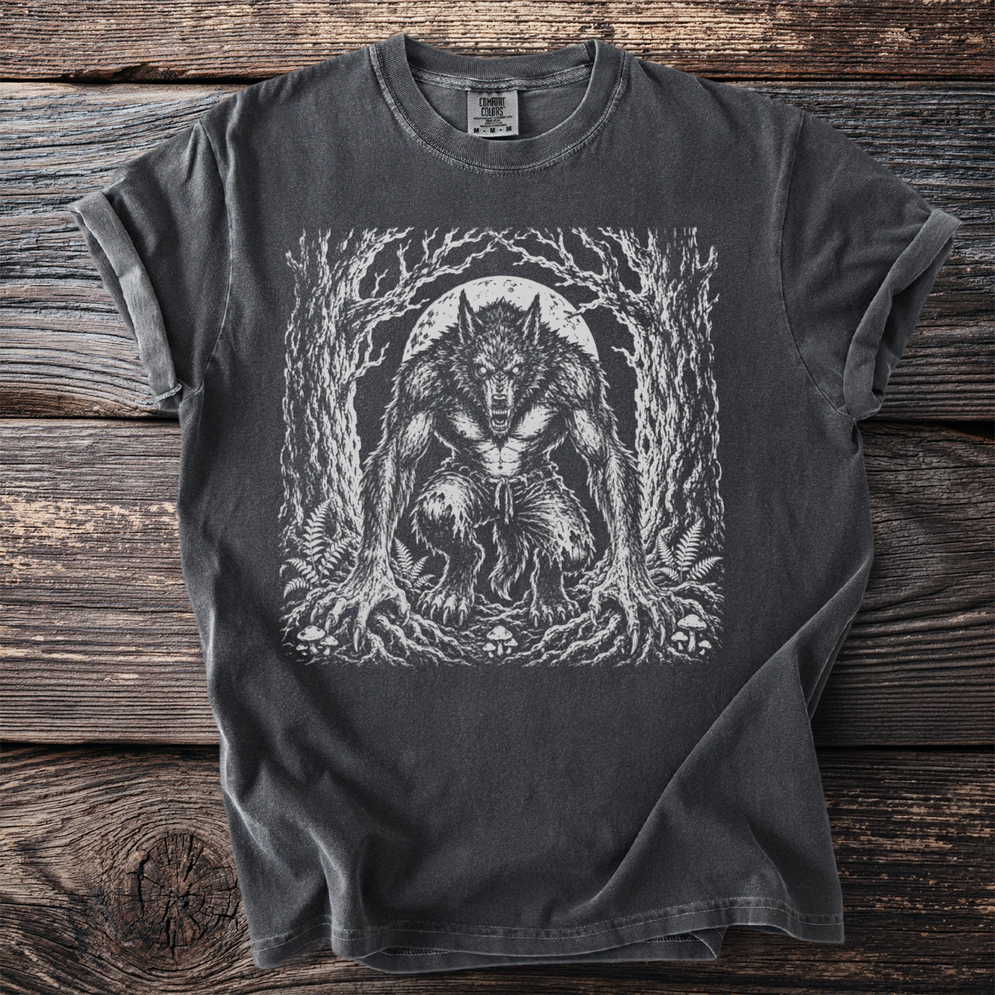 Werewolf illustration on a dark gray t-shirt with a full moon and forest background.