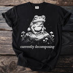 Black t-shirt with a frog sitting on a rock and the text "currently decomposing".