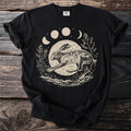 Black t-shirt with a linocut style print of a running hare under a moon and celestial phases.
