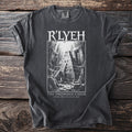 Dark t-shirt with white graphic of R'LYEH and "The Drowned Choir Even Death May Die" text.