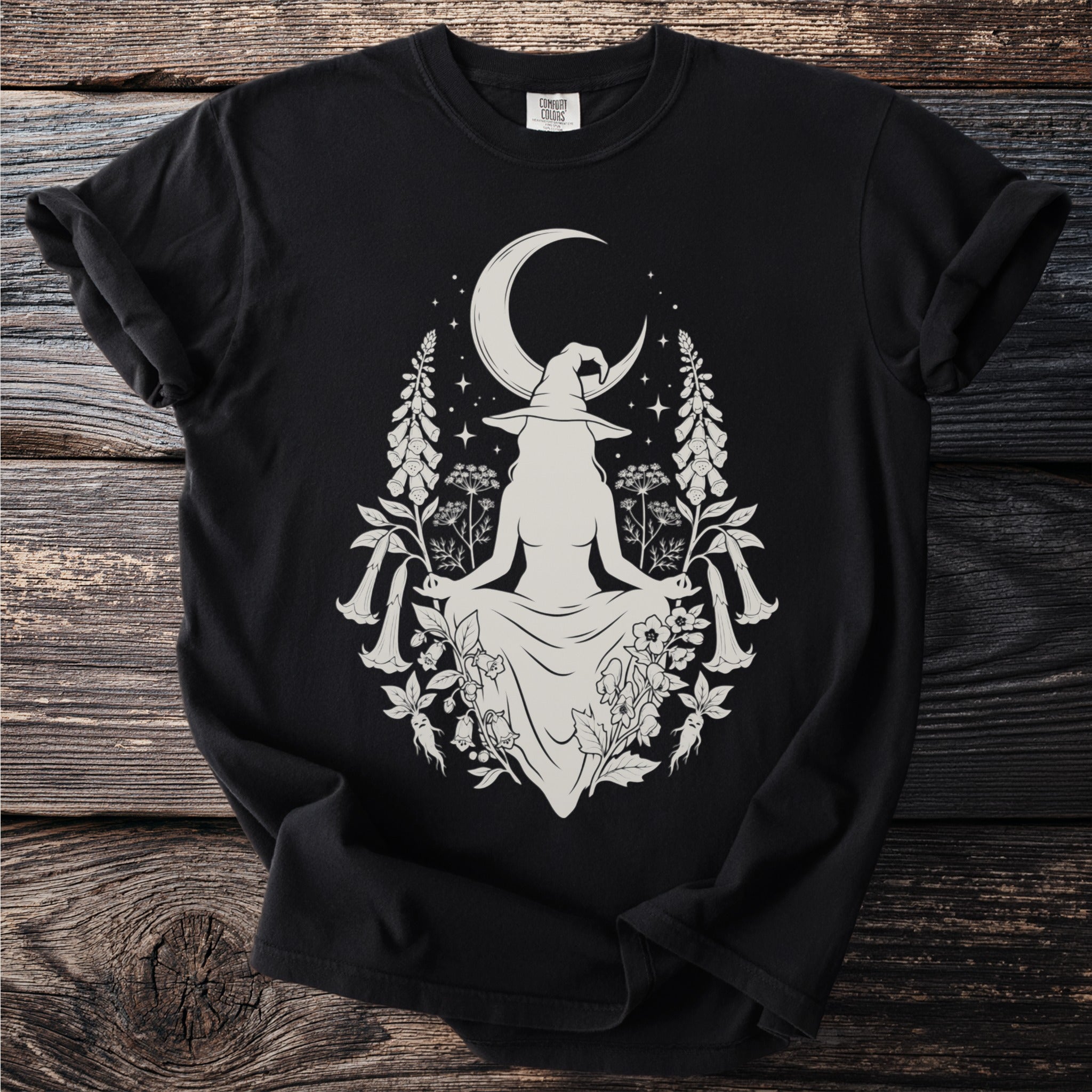 Witch with crescent moon and floral design on black t-shirt.