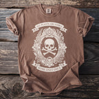 Brown t-shirt with a cream oval graphic of a skull and crossbones, botanical elements, and text.