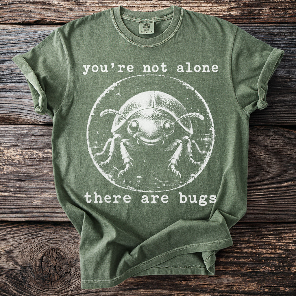 Green t-shirt with a circle graphic of a smiling beetle with text above and below.