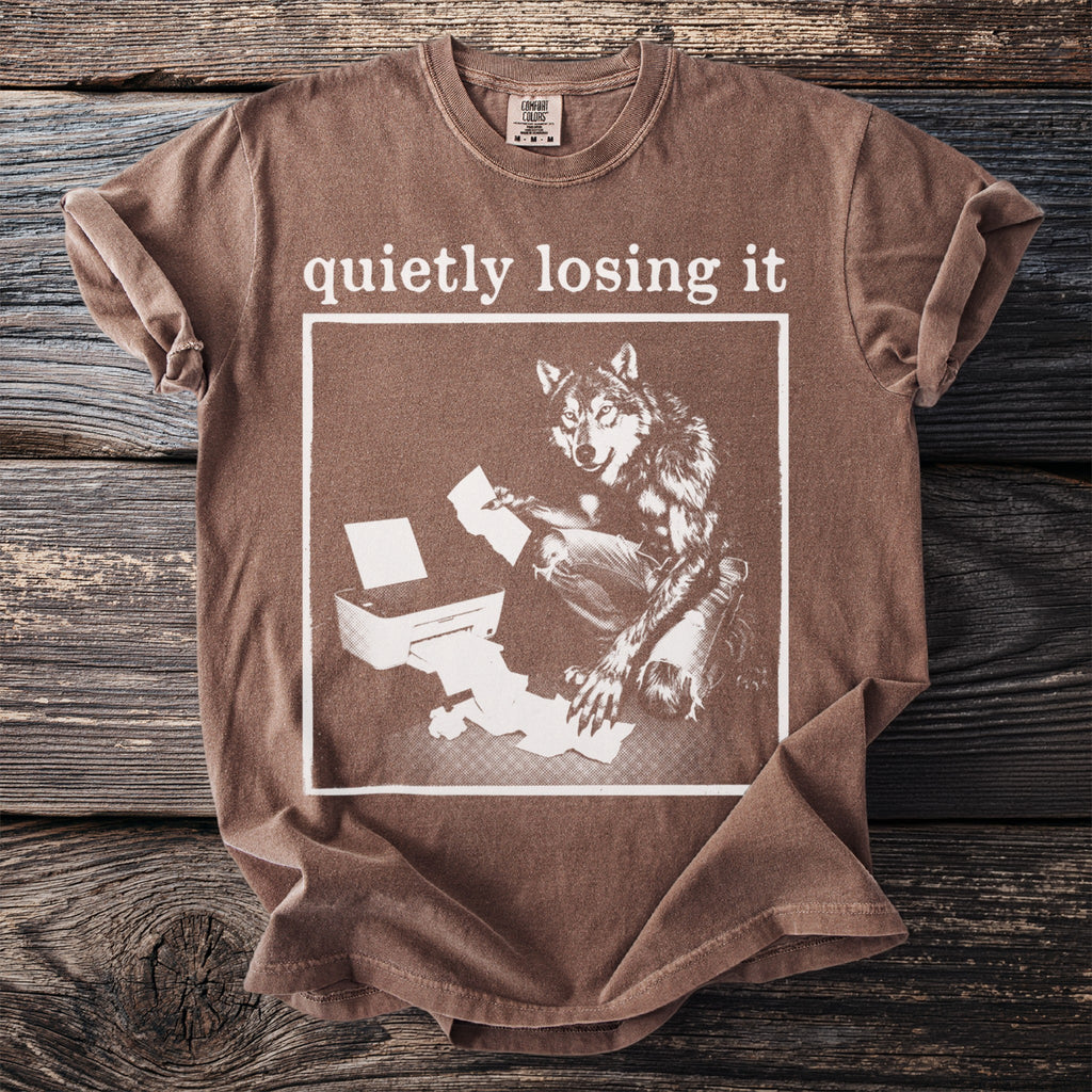 Brown t-shirt with graphic of wolf at printer and text "quietly losing it".