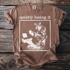 Brown t-shirt with graphic of wolf at printer and text "quietly losing it".