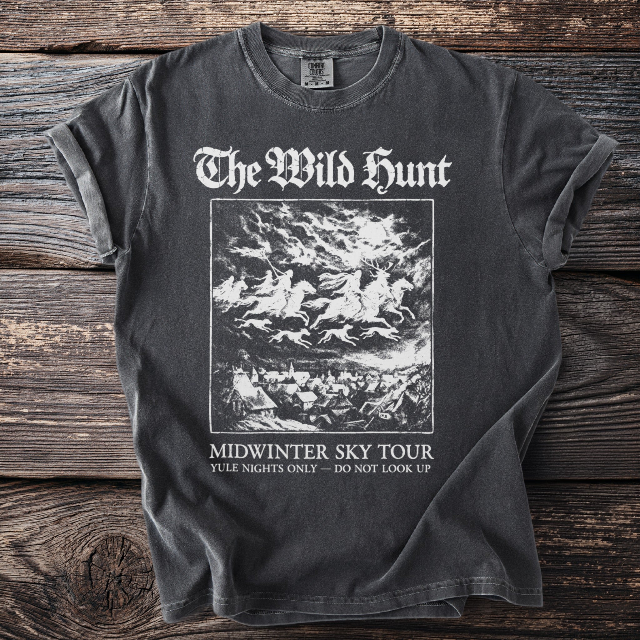 The Wild Hunt Midwinter Sky Tour t-shirt with riders and dogs over a village.