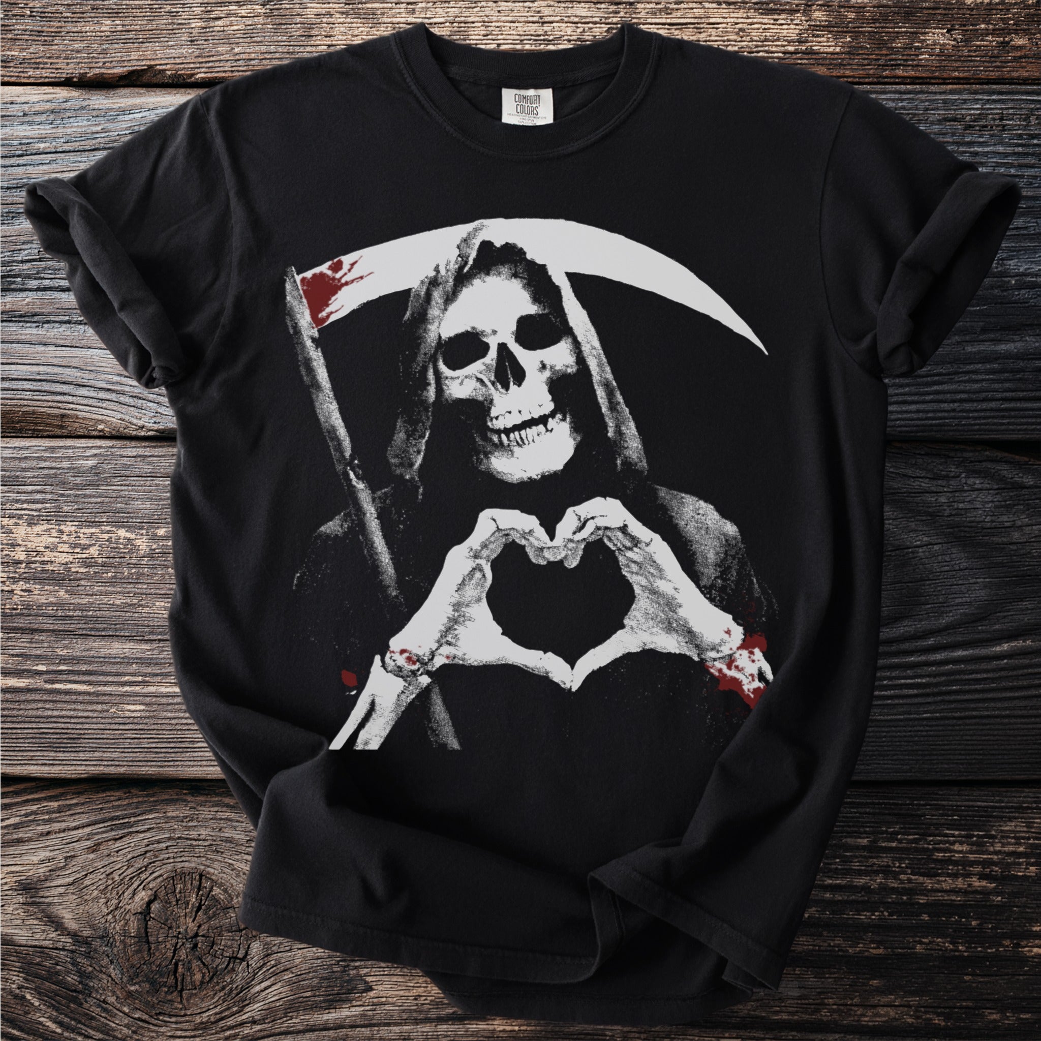 Grim reaper skeleton with bloody scythe forms heart shape with hands.