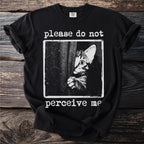 Black t-shirt with a distressed print of a cat peaking from behind a curtain, reading "please do not perceive me".