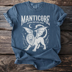Blue t-shirt with a white graphic of a manticore with wings and a scorpion tail.