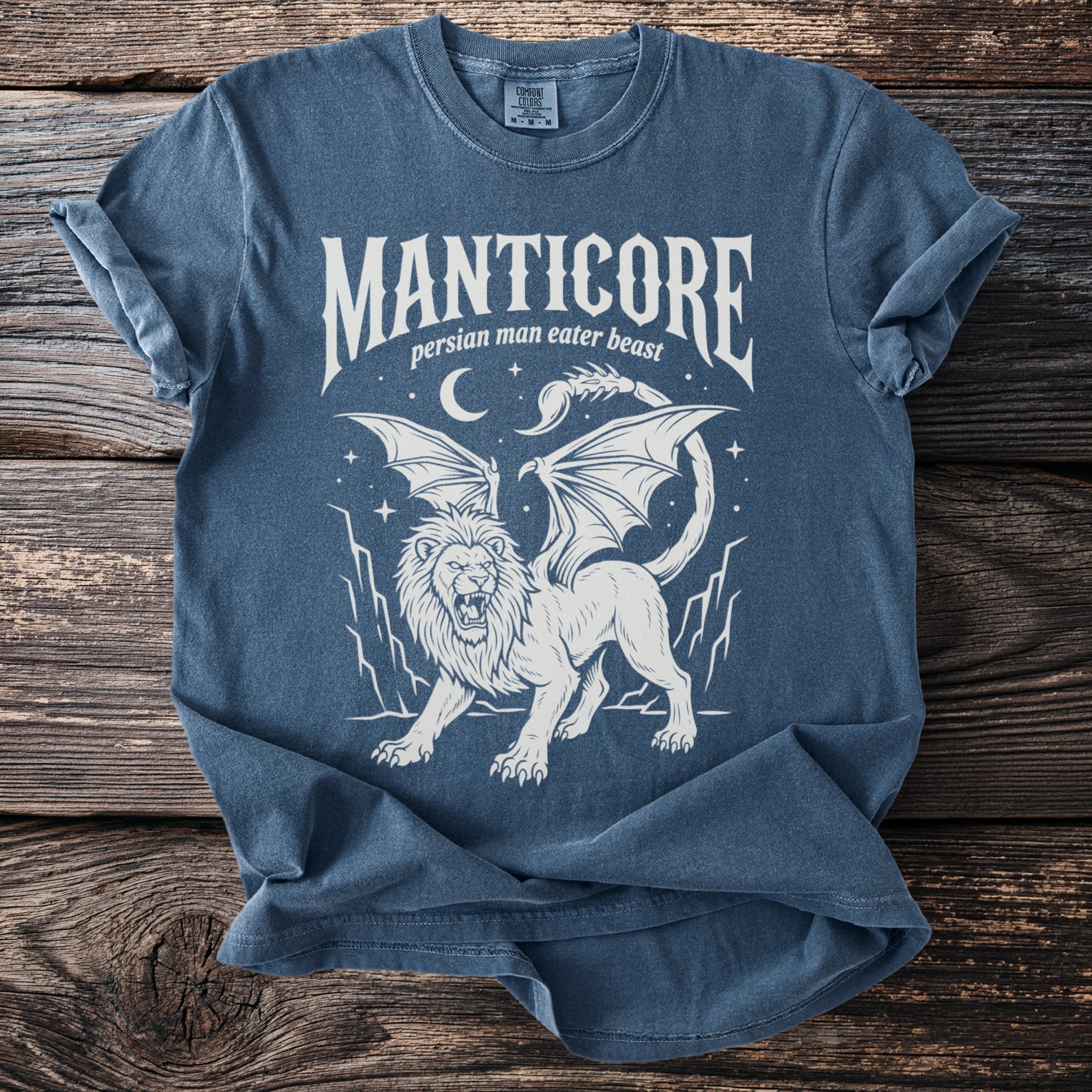Blue t-shirt with a white graphic of a manticore with wings and a scorpion tail.