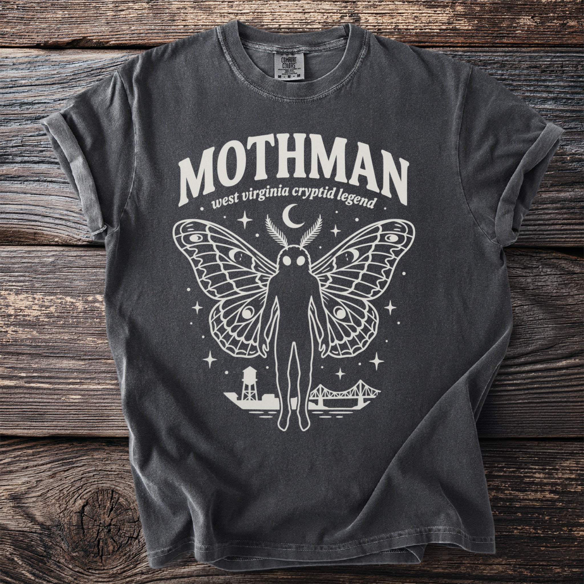 Dark grey t-shirt with white Mothman graphic, "west virginia cryptid legend" text.