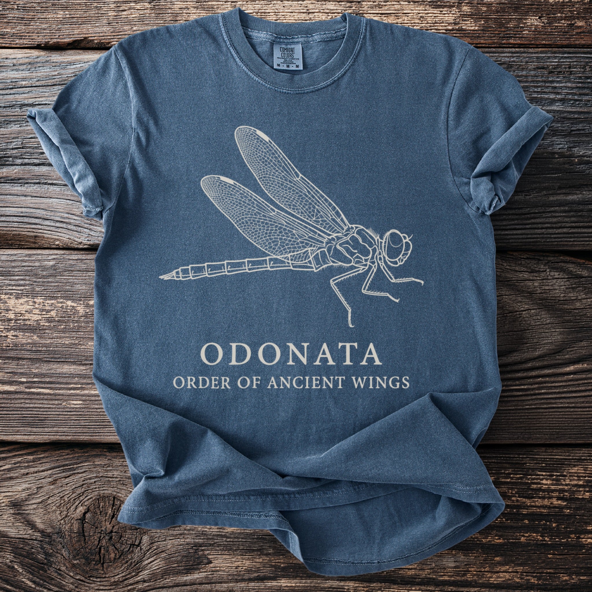 Blue t-shirt with a white line drawing of a dragonfly and text "ODONATA ORDER OF ANCIENT WINGS".